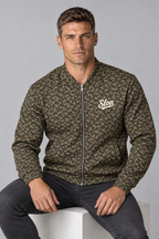 Man wearing the Slop Script Bomber Jacket in Woodland Camo, seated