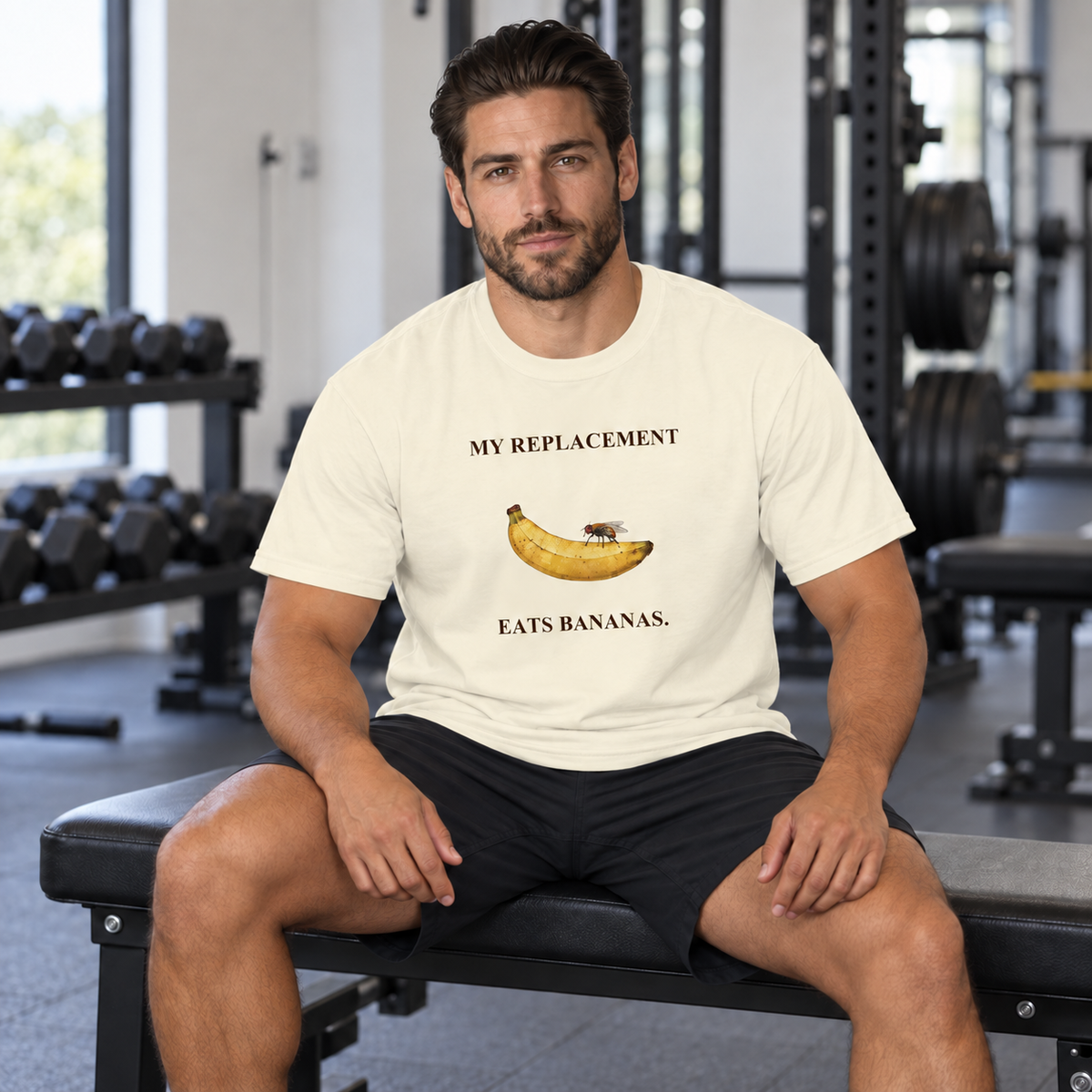 My Replacement Eats Bananas Tee — Ivory — CW-M17 fictional adult model, seated hands on thighs; exact provider garment and artwork; digital mockup.