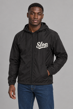 Digital mockup: 098 black AA M02 standing v1; actual EXP54LWZ windbreaker, cream Slop on wearer-left chest only.