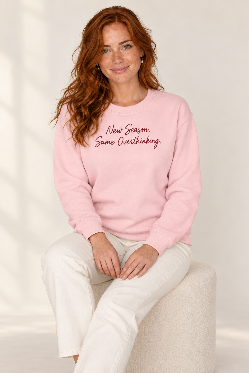 Claire Rowan wearing the Light Pink script sweatshirt, seated view
