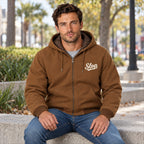 Man wearing the Slop Script Duck Work Jacket in Duck Brown, seated
